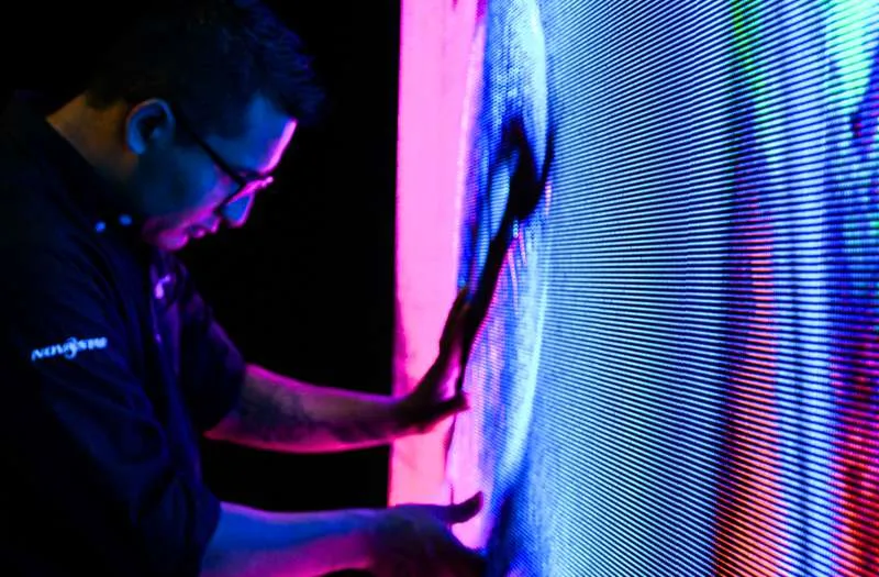 Técnico instalando pantalla LED con soporte certificado